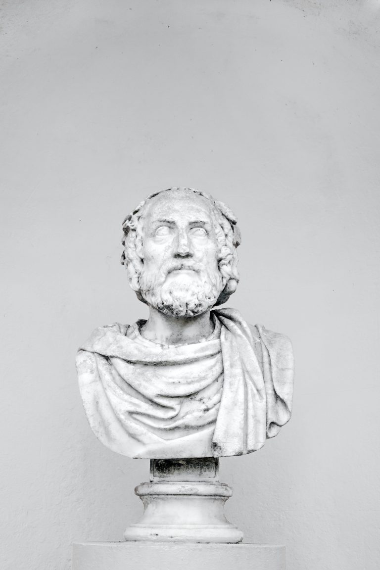 Vertical shot of a bust of a philosopher isolated on a grey background